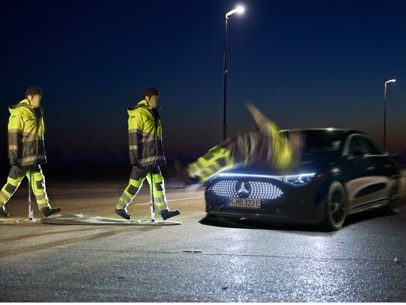Ein dunkles Auto kollidiert nachts im ADAC-Test mit einem Dummy in reflektierender Warnkleidung.